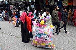 People select and purchase second-hand shoes from vendors at the weekly Sunday Bazaar at H-9 in the Federal Capital