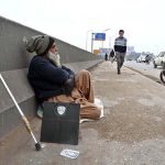 An elderly vendor, with his weighing machine at Khana Pul, waits for customers to earn his livelihood
