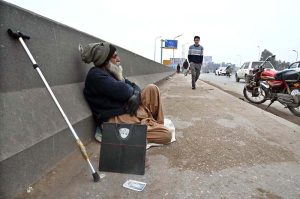 An elderly vendor, with his weighing machine at Khana Pul, waits for customers to earn his livelihood