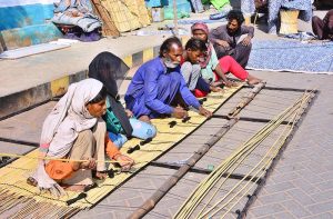 A family labour team busy preparing traditional bamboo curtains (chiks) at Court Road.