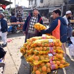 A vendor displays orange sacks for sale to attract customers at a fruit and vegetable market in the Federal Capital