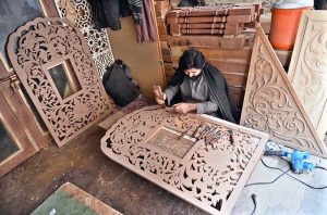 A carpenter busy making different design on wooden piece at Saidpur Road.