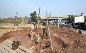 Labourers are busy digging a hole to install an electric pole at Khana Pul.