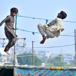 Gypsy youngsters enjoy jumping on the trampoline near Railway Station.
