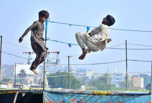 Gypsy youngsters enjoy jumping on the trampoline near Railway Station.