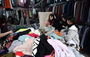People select and purchase second-hand shoes from vendors at the weekly Sunday Bazaar at H-9 in the Federal Capital