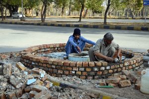 CDA workers plant saplings on the green belt near the fire brigade in the Federal Capital