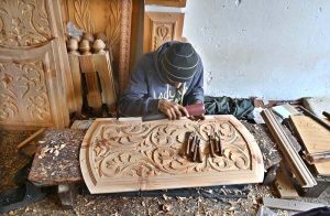 A carpenter busy making different design on wooden piece at Saidpur Road.