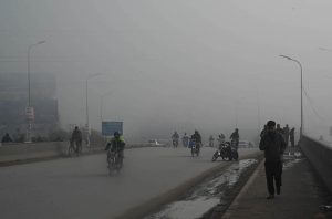 Motorcyclist pass through dense fog in the early morning along the expressway in the Federal Capital.