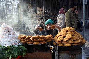 A vendor busy in roasting corn cobs at his roadside setup at Pirwadhai area