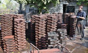 A labourer is busy preparing tuff tiles in a local factory in the Federal Capital
