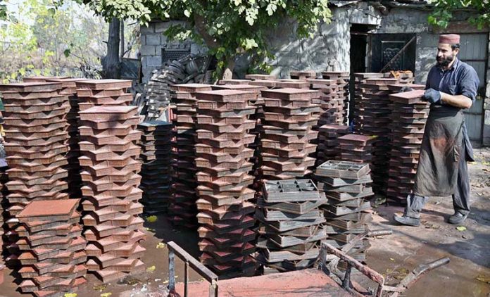 A labourer is busy preparing tuff tiles in a local factory in the Federal Capital