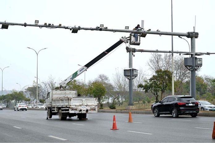 A worker busy repairing CCTV cameras during maintenance work at Srinagar Highway in Federal Capital