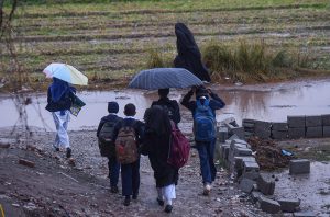 A view of rainfall as students head towards their schools in the Tarlai area of Federal Capital