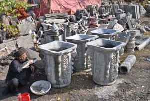 A labourer is busy preparing tuff tiles in a local factory in the Federal Capital