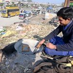 A vendor busy roasting corn cobs for customer at his setup in Pirwadhai