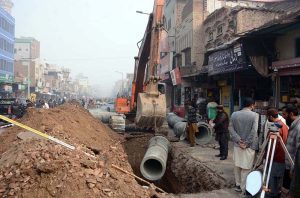 WASA workers lay a new sewerage pipeline at Jhang Bazaar using heavy machinery.