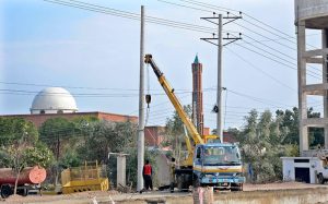 Workers install a new electricity pole during development work at the Southern Bypass.