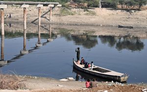 A boatman ferries locals across the Phuleli Canal with the help of a rope.