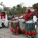 Drum players wait for customers along the roadside in the federal capital