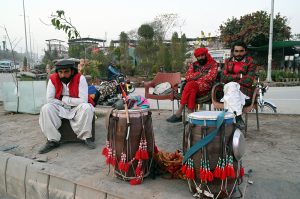 Drum players wait for customers along the roadside in the federal capital