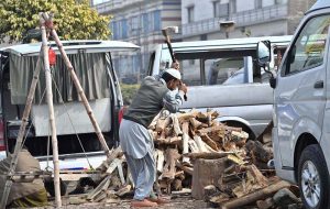 A labourer is busy cutting wood into pieces at his workplace at the Pirwadhi Fruit and Vegetable Market in the Federal Capital