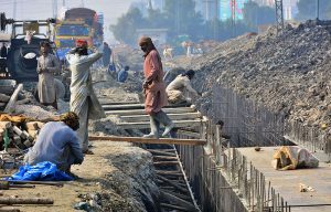 Labourers are busy construction work of sewerage nullah at Tando Yousuf Road during development work in the city.