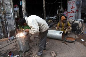 People sitting around a fire to keep warm amid cold weather