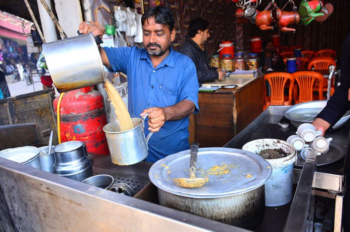Amid the chill, a vendor prepares hot special tea to warm up customers at a local hotel