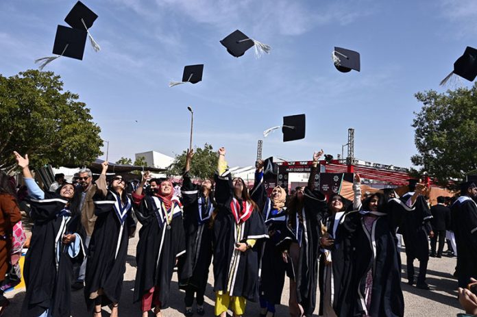 Successful students throw their caps in celebration during the 29th Academic Convocation and Career Fair 2026 ceremony at Mehran University of Engineering & Technology