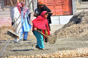 Labourers busy in construction work of sewerage line at autobahn road during development work in the city.