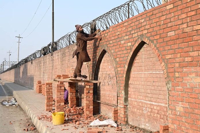 A laborer is working on the construction of the arch of the railway station wall, a symbol of the city’s beauty