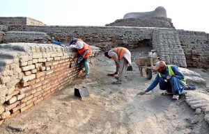Labourers are busy repairing work of the walls in front of Stupa at world famous archeological site of Mohen jo-Daro (Mound of Dead).