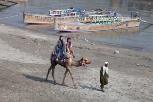 Girls enjoying camel ride near Indus River at Jamshoro.