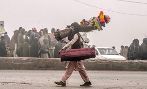 A vendor moves along the road selling household items in the Khanna Pul area of the federal capital.