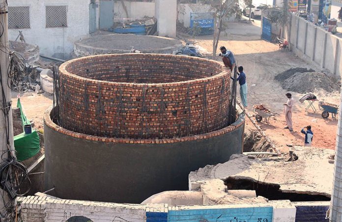 Workers are constructing a large main sewage disposal line at Chungi No. 09