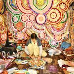A worker is busy preparing a money necklace at his workplace during the wedding season.