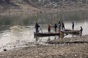 Fishermen catch fish using net at Pinyari Canal