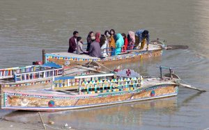 Girls enjoying camel ride near Indus River at Jamshoro.