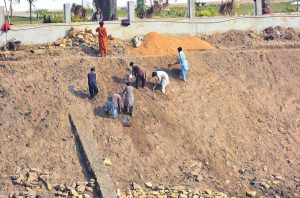Workers of the Irrigation Department are busy preparing the canal embankments in the Jamshoro area