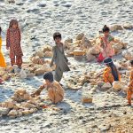 Children are enjoying playing with stone at dry area of Indus River