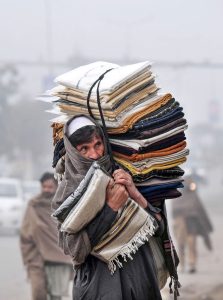 An elderly vendor on the way while carrying shawls to search the customers at KhanaPul.