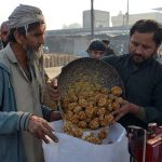 Labourers weigh traditional jaggery “Gur” for sale at Gur Mandi, meeting the city’s winter sweet cravings