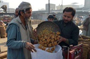 Labourers weigh traditional jaggery “Gur” for sale at Gur Mandi, meeting the city’s winter sweet cravings