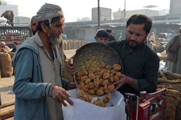 Labourers weigh traditional jaggery “Gur” for sale at Gur Mandi, meeting the city’s winter sweet cravings