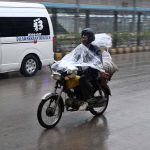 motorcyclist covered himself with a plastic sheet to protect from rain that experienced in the Provincial Capital.