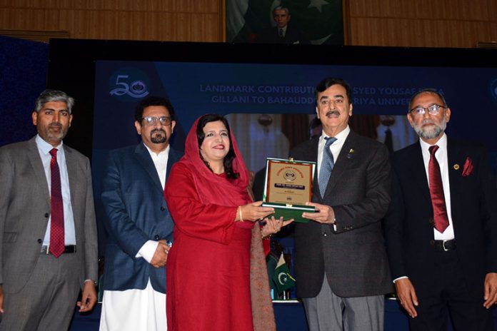 Chairman Senate Syed Yousaf Raza Gillani distributes shields among participants during the oath-taking ceremony of the newly elected body of the Academic Staff Association at Bahauddin Zakariya University