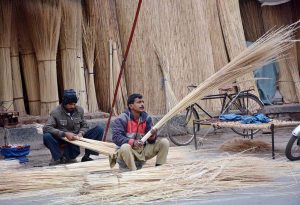 Worker busy in making handy domestic brooms at their workplace.