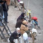 Labourers along with their tools waiting for daily job while sitting on roadside