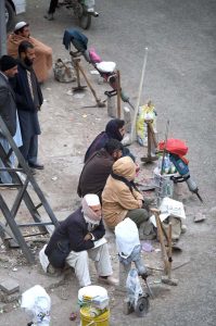 Labourers along with their tools waiting for daily job while sitting on roadside